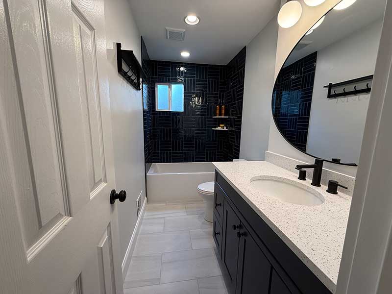 Experienced bathroom remodeler measuring tile layout and fixture placement for luxury renovation