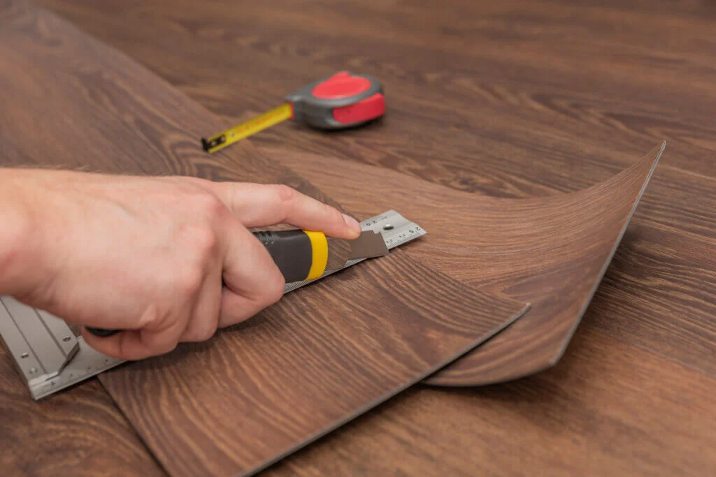 Skilled flooring contractor installing hardwood floors in a Bothell living room with large windows and natural light