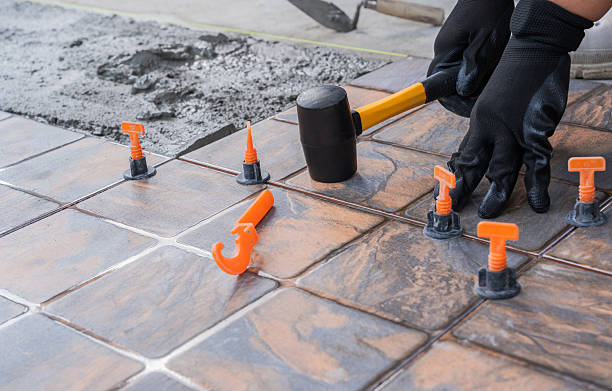 Tile Contractor in Bellevue, WA aligning large-format floor tiles inside a bright kitchen remodel