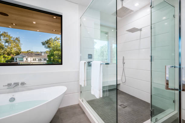 Contractor measuring a Shower Remodel layout inside a Sammamish, WA bathroom before waterproofing and fixture placement